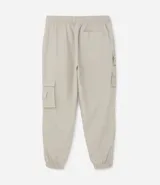 Pantalón jogger color beige, confeccionado en tejido plano de poliamida, con cintura elástica y cordón de ajuste. Presenta múltiples bolsillos cargo con solapa en los laterales y elástico en los puños.