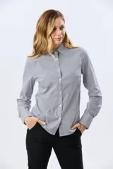 Camisa de manga larga con diseño de rayas verticales, confeccionada en mezcla de algodón, nylon y spandex. Cuenta con cuello camisero clásico y cierre frontal abotonado.