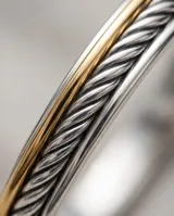 Esclava rígida de plata 925 con diseño trenzado y detalle de lámina de oro de 18k en la parte superior.