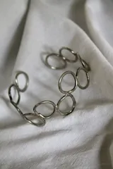 Pulsera rígida plateada hecha en alpaca, con diseño de eslabones circulares.