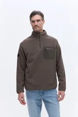 Buzo de polar color marrón con cuello alto y cierre frontal parcial. Presenta un bolsillo frontal con cierre en contraste de color y mangas largas.