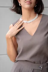 Blusa sin mangas color gris oscuro, con escote en V y corte sastrero.