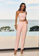 Pantalón de mujer color rosado con detalles de encaje en los laterales de la cintura, de corte recto y tiro alto.