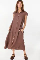 Vestido midi color azul de lino italiano, con diseño camisero, cuello camisero, mangas cortas abullonadas, cierre frontal con botones y bolsillos laterales.