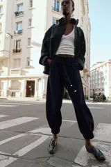 Pantalón jogger de tiro medio, color bordó, con cintura elástica ajustable mediante cordones, bolsillos delanteros y puños elásticos en los tobillos.