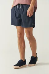 Short de baño liso para hombre, con cintura elástica y cordón ajustable. Cuenta con dos bolsillos laterales, un bolsillo trasero y logo bordado en la parte inferior.