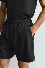 Pantalones deportivos cortos de Zara Athleticz, confeccionados en tejido técnico ligero y elástico. Presentan cintura elástica ajustable con cordón interior, bolsillos frontales, bajo con perforaciones decorativas y aberturas laterales, con detalle de logo estampado en la pierna.