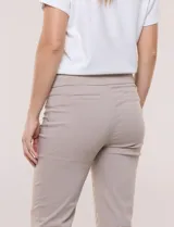 Pantalón color beige de corte entallado y largo cropped, confeccionado en tejido de punto con elasticidad técnica. Cuenta con pretina ancha y plana, bolsillos simulados al frente y bolsillos tipo ojal en la parte posterior.