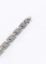 Pulsera de eslabones de acero quirúrgico plateado con ranuras diagonales.
