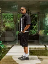 Bermuda negra de gabardina, corte ancho y largo, con bolsillos laterales.