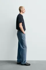 Pantalón de jean con corte recto desde la cadera y leve ensanchamiento en el bajo. Presenta tiro medio, cinco bolsillos, cierre frontal con cremallera y botón, y un acabado con efecto lavado.