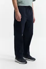 Pantalón de gabardina color azul marino, con diseño de cinco bolsillos, corte relajado, cintura elastizada con cordones ajustables y terminación recta sin puños.