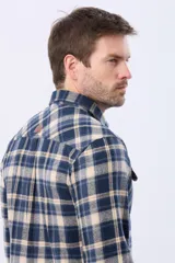 Sobrecamisa de viyela a cuadros en tonos azul, beige y marrón, con dos bolsillos de parche con solapa abotonada en el pecho.