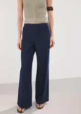 Jeans Avery de corte wide leg y tiro medio, con diseño largo, bolsillos laterales y traseros, y cierre oculto con botón, gancho y cremallera.