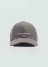 Gorra de béisbol de algodón color gris, con diseño minimalista y mensaje bordado en el frente. Cuenta con cierre ajustable metálico en la parte posterior.