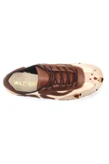 Championes de cuero con diseño de paneles orgánicos en tonos tierra. Presenta una combinación de cuero liso marrón y beige, con detalle de cuero con pelo estampado tipo vaca en la puntera. Cuenta con cordones al tono y suela blanca.