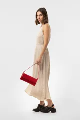 Vestido midi sin mangas de color marrón, confeccionado con textura arrugada, escote redondo, silueta relajada y caída liviana, con un lazo fino ajustable en la cintura.