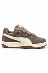 Championes Puma modelo Park Luna de color marrón topo, confeccionados en gamuza con detalles en cuero sintético blanco crudo, cordonera gruesa y suela de goma marrón.