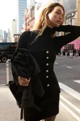 Top strapless confeccionado en tejido de terciopelo negro, con cierre frontal de botones metálicos dorados y bajo con abertura central.