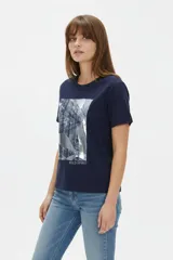 Remera de algodón azul marino, de manga corta, con cuello redondo y diseño holgado. Cuenta con un estampado frontal abstracto con detalles metálicos estilo foil y la inscripción "Wild Spirit".