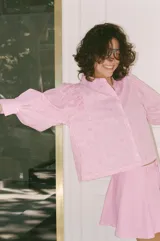 Camisa de manga larga con cuello solapa, cierre frontal con botones y puños abotonados. Presenta un diseño de rayas verticales combinadas con un estampado floral lineal superpuesto.