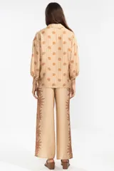 Camisa de manga larga color rosa con rayas verticales rojas y estampado de flores rojas. Con cuello camisero, puños elastizados y lazos regulables en los costados del ruedo.