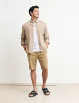 Camisa de manga larga confeccionada en una mezcla de algodón y lino, con cuello abotonado, bolsillo frontal en el pecho y cierre de botones.
