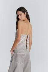 Top de fiesta color crema con lentejuelas plateadas y breteles finos.