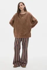 Buzo de algodón color crema, con cuello redondo y mangas largas, de calce oversize y hombros caídos. Presenta un pequeño bordado en el pecho.