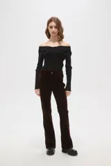 Pantalon de corte flare y tiro alto, confeccionado en tejido de pana color marrón oscuro, con cierre frontal y bolsillos laterales.