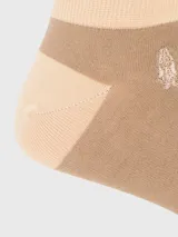 Calcetín corto tipo soquete de algodón, color beige con detalles en tono arena en talón, puntera y puño. Presenta el logo de la marca bordado en el lateral.