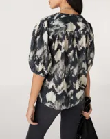 Camisa de manga corta con estampado abstracto en tonos blanco, negro y gris.