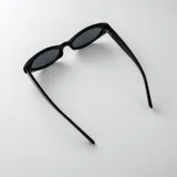 Lentes de sol con armazón carey de diseño ovalado, patillas anchas con detalle de pespuntes metálicos y cristales marrones degradados.