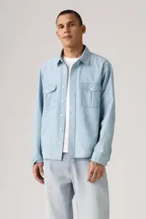 Camisa celeste de jean con dos bolsillos frontales con solapa y cierre de botón.