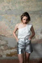 Musculosa blanca de lino con un solo hombro y volados en el hombro. Tiene elástico en la espalda para adaptarse a varios talles.