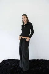 Pantalón de tiro alto con corte amplio y recto, presenta pinzas en la cintura y bolsillos laterales. Confeccionado en tela liviana de textura natural con caída suelta.