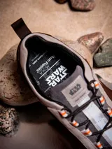 Zapatillas Hush Puppies edición limitada inspiradas en Luke Skywalker, con diseño en tonos tierra, beige y marrón. Presentan una combinación de cuero y descarne, con detalles de Star Wars grabados en el lateral y en la lengüeta, y cordones con detalles en naranja.