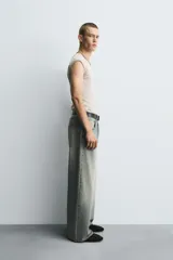 Jeans de denim de algodón, color azul oscuro con efecto lavado. Presentan un corte muy holgado (baggy fit) en toda la pierna y tiro medio. Tienen cinco bolsillos y cierre frontal con cremallera y botón.