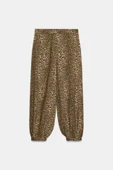 Pantalón bombacho de tiro medio con estampado animal print, bolsillos delanteros, bajo con puño y cierre frontal con cremallera y gancho metálico.