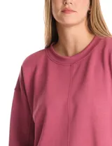 Buzo deportivo de cuello redondo, con hombros caídos y mangas largas con puños. Presenta costuras decorativas tipo pespunte en la parte frontal y en las mangas, con un diseño de ruedo recto y tajos laterales.