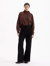 Polera de tejido de punto color marrón, con cuello alto y diseño holgado de corte oversize.