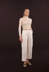 Blusa de punto color beige, de cuello alto y manga larga.