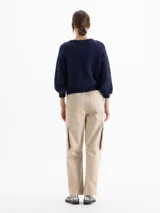 Pantalón cargo de corte recto y largo al tobillo, color beige. Presenta cintura elastizada con lazo ajustable, bolsillos laterales con tapa estilo utilitario y bolsillos adicionales en el delantero y la espalda.