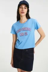 Remera de algodón color azul claro con estampado frontal estilo universitario con el logo de Levi Strauss and Co. en tonos rosados y violetas. De corte estándar y cuello redondo.