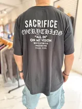 Remera oversize negra de manga corta con estampado tipográfico blanco en la espalda.