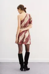 Vestido corto de un hombro, con manga larga y frunces en el hombro. Presenta ajuste elástico en la cintura y cierre invisible lateral. Confeccionado en tejido jacquard con lurex y forrería a tono.