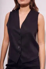 Chaleco de corte sastre con escote en V y cierre frontal de botones. Presenta un diseño sin mangas, entallado al cuerpo, confeccionado en una mezcla de lino y viscosa.