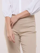 Pantalón de gabardina elastizada color beige, de tiro medio y calce slim. Cuenta con diseño pull-on sin cierres ni botones, cintura ancha, bolsillos delanteros simulados y bolsillos traseros ojal.