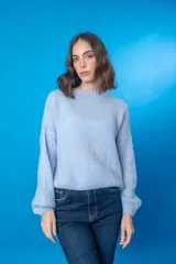 Sweater color beige de lana mohair y acrílico, con cuello redondo y mangas largas.