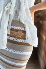 Pollera tejida a rayas horizontales en tonos beige, marrón y blanco.